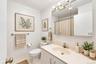 White vanity with an integrated oval sink, chrome faucet, and mirrored medicine cabinet