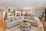 Hardwood-finish flooring throughout, recessed lighting, built-in shelving with patterned backing, crown molding, and a modern chandelier
