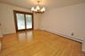 Photo Visually Staged.  The Dining Room has hardwood floors, opens to both the Kitchen and Living room and has sliding glass doors to the back patio a