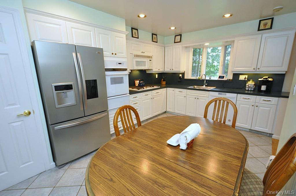 Updated Eat-in-kitchen with granite counters, Stainless Steel French Door refrigerator, wall oven, stove top, and microwave.  There is a window over t
