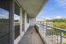 Tiled balcony with a white metal railing and a sliding glass door