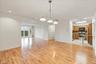 Hardwood flooring throughout the main living area, with a kitchen featuring wood cabinetry, stainless steel appliances, and a tiled floor