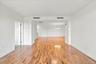 Hardwood flooring throughout, white painted walls, recessed lighting, and a contemporary pendant light fixture
