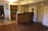 Apartment. Wood-finish flooring, built-in bar, and a kitchen area with wood cabinetry