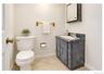 Compact bathroom featuring a vanity with an integrated sink, wall-mounted mirrored medicine cabinet, and tile flooring