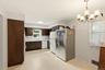 Kitchen featuring wood-finish cabinetry, light-toned countertops, and a ceiling-mounted light fixture