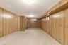 Wood-finish wall paneling, recessed lighting, and vinyl flooring