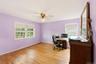 Hardwood flooring, multiple windows, ceiling fan, and ample wall space