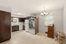 Kitchen featuring dark wood cabinetry, white appliances, and a window above the sink