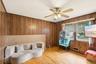 Wood-paneled walls and a ceiling fan with integrated lighting