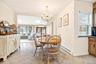 Dining area featuring a chandelier, light tile patterned floors, ornamental molding, french doors, and a skylight