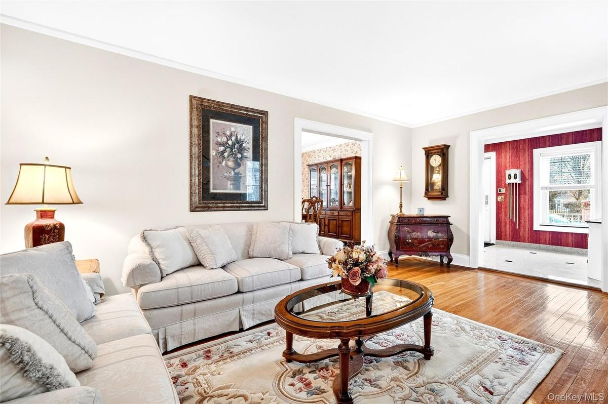 Living room featuring hardwood / wood-style floors, plenty of natural light, and ornamental molding