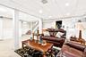 Living area with a paneled ceiling, light tile patterned flooring, stairs, and wainscoting