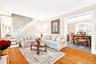 Living area featuring crown molding, stairway, a chandelier, and wood-type flooring