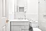 Full bath featuring vanity, tile walls, a tile shower, and decorative backsplash