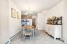 Dining room featuring a baseboard radiator, ornamental molding, a chandelier, and light tile patterned floors