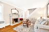 Living room featuring a fireplace, wood finished floors, and radiator heating unit