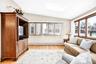 Living room featuring vaulted ceiling, light wood-type flooring, a skylight, a baseboard heating unit, and recessed lighting