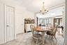 Dining room with crown molding, a chandelier, french doors, light tile patterned floors, and a skylight