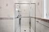 Glass-enclosed shower with a handheld showerhead