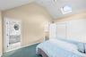 Vaulted ceiling with skylight and ceiling fan, neutral wall tones, and sliding closet doors