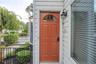 Warm entry door with an arched transom, detailed paneling, and an integrated smart lock