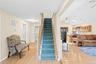 Hardwood-finish flooring, staircase with carpeting, open-concept design, vaulted ceiling, and skylight