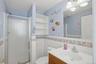 The bathroom features a vanity with a white sink and a mirror above