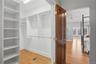 Walk-in closet featuring extensive built-in shelving and hanging rods