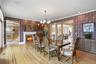 Dining area featuring hardwood floors, a fireplace, and decorative wall coverings