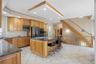The kitchen features wood cabinetry, dark countertops, and modern appliances