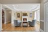 Living area featuring hardwood floors, a fireplace with a white mantel, recessed lighting, and large windows providing natural light