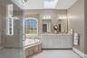 The bathroom features a spacious shower with a glass enclosure, a corner bathtub, and a dual vanity with two mirrors and overhead lighting