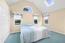 Vaulted ceiling, arched window, skylight, and wall-to-wall carpeting