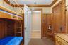 Built-in bunk bed with ladder, wood paneling, wood-finish door, and carpet flooring