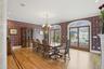 This elegant dining area features hardwood floors, decorative wall coverings, and arched glass doors that provide views of the outdoor patio
