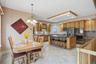This property features a kitchen and dining area with hardwood cabinetry, a kitchen island with seating, a large refrigerator, and a double oven