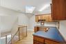 This versatile space features a built-in wooden desk and cabinetry, complemented by a skylight and hardwood flooring