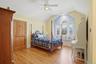 This room features light hardwood flooring, a window seat with a view, and a ceiling fan