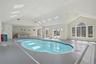 Indoor swimming pool area with skylights, large windows, and a vaulted ceiling