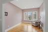 This room features hardwood floors, three windows providing natural light, and recessed ceiling lighting