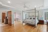This spacious room features hardwood floors, a ceiling fan, recessed lighting, and windows providing natural light