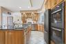 The kitchen features solid wood cabinetry, a large kitchen island with a sink, a gas stovetop, and stainless steel appliances