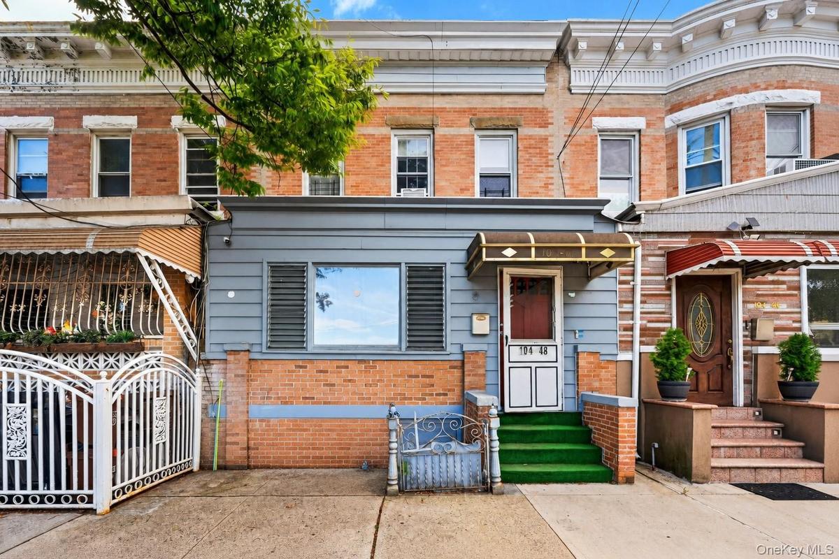 Brick facade with siding accents, front entry door with canopy, and a gated driveway