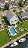 Digitally staged yard featuring pool and fire pit .