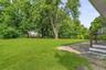 Sprawling yard with mature tress for privacy.