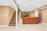 Recessed lighting illuminates this expansive space featuring tile flooring and a built-in media center