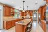 Kitchen featuring wood cabinetry, granite countertops, tile flooring, and recessed lighting