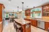 Kitchen featuring a large island with stone countertop, stainless steel appliances, recessed ceiling lights, and arched windows