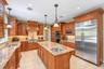 Kitchen featuring wood cabinetry, light-toned countertop, stainless steel appliances, and recessed lighting